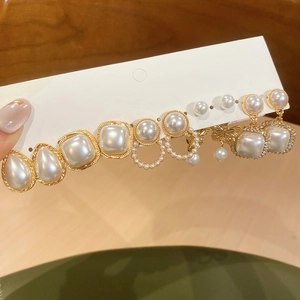 Detailed close-up of pearl earring set with golden butterfly and sparkling crystal charms