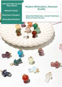 Close-up of assorted natural crystal mushroom pendants with gold loops on shell tray