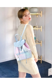 Detail view of light blue gradient backpack with drawstring closure and star patterns