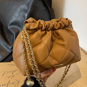 Brown quilted crossbody bucket bag with golden chain and metallic ball charm details