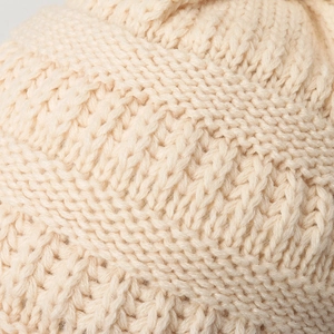 Bonnet en grosse maille torsadée avec pompon blanc crème en laine douce pour l'hiver