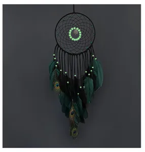Detailed view of peacock feathers and glowing beads on tree of life dream catcher