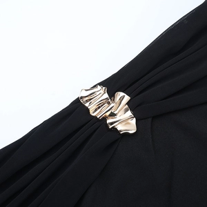 Detail of sheer black mesh fabric featuring a stylish curved gold metal buckle accent
