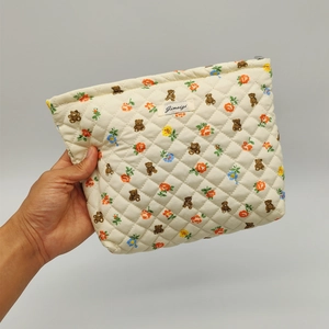 Quilted floral teddy bear cosmetic bag in cream white with a zipper closure