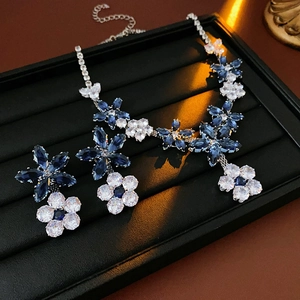 Vintage floral jewelry set with blue and white crystals on black velvet tray