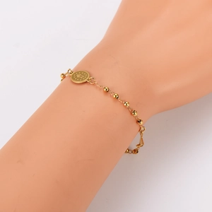 Classic gold bead bracelet with oval coin star pendant on female model wrist