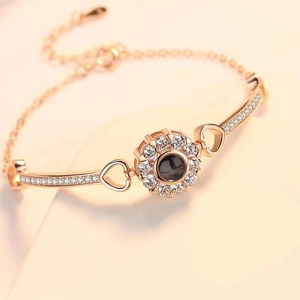 Rose gold projection bracelet with circular pendant and crystal inlay for a custom gift