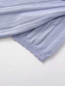 Detailed view of lavender knit fabric with chevron texture and wavy scalloped hem