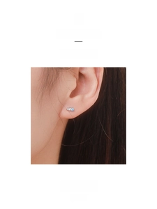 Close-up of minimalist S925 silver stud earrings featuring blue and white zircon stones