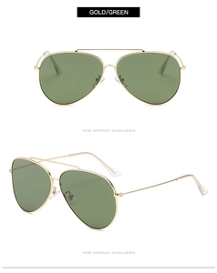 Close-up of classic gold metal aviator sunglasses with green lenses and double bridge