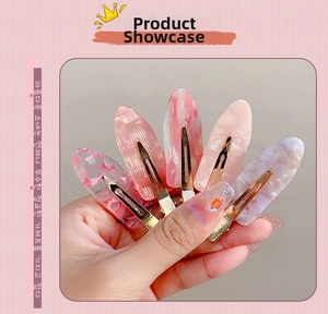Close-up of five pink acetate hair clips with marble patterns and glitter finishes