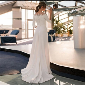Elegant white long-sleeve lace wedding gown with a slim fit and sleek satin train