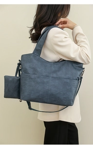 Detail view of large navy blue tote bag with litchi texture and crossbody strap
