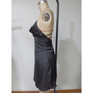 Détail de la robe courte en satin noir avec bretelles croisées et coupe ajustée