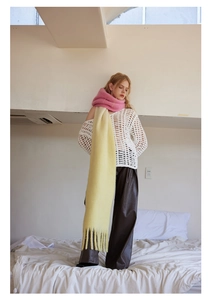 Detail of soft knit scarf with pink and yellow gradient and handmade fringe tassels