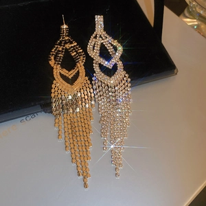 Close-up of elegant long tassel earrings with sparkling diamonds and gold-silver finish