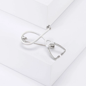 Detail of silver stethoscope brooch with white enamel on a professional display