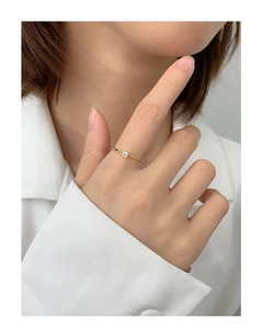 Close-up of elegant gold plated four-prong solitaire zircon ring on female finger