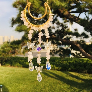 Macro view of crystal moon suncatcher with rose quartz stones and butterfly pendants