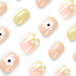 Short round press-on nails with green and white checkerboard and cute flower patterns