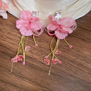 Detailed view of pink fabric flower earrings with crystal studs and beaded tassel fringe