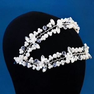 Exquisite bridal headband featuring crystal flowers and pearls on a sleek black display