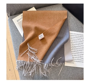 Detail of pure goat hair scarf with water ripple pattern and brand label on a sofa