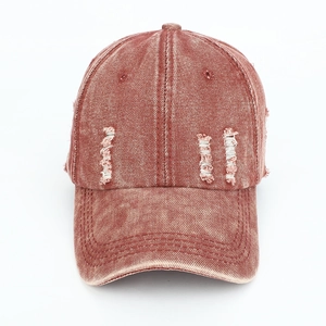 Detailed view of vintage washed brick red baseball cap with distressed rip texture