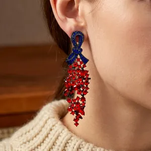 Boucles d'oreilles nœud vintage avec cristal bleu et pompons de fleurs rouges sur mannequin