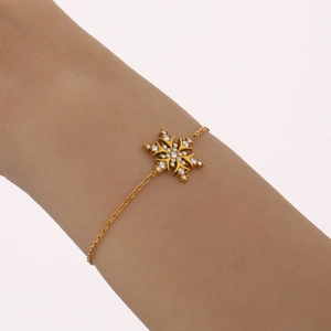 Gold-plated 18K stainless steel snowflake bracelet with shimmering cubic zirconia on wrist