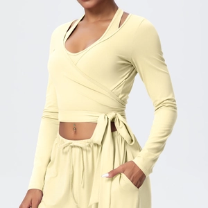 Detail of pale yellow yoga wrap top with side-tie bow and layered athletic design