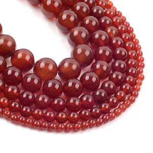Macro detail of red agate round beads showing smooth polished finish and diverse sizes