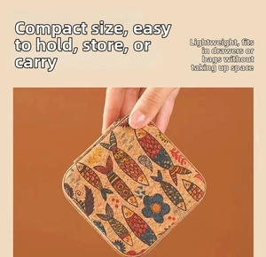 Detail of mini square cork jewelry box with vintage fish print held in hand