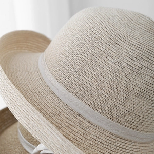 Gros plan sur la texture du chapeau de paille tissé avec ruban élégant en soie grise