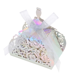 Macro view of laser-cut floral patterns on iridescent white favor box with ribbon