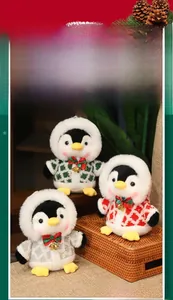 Detailed view of three Christmas penguin plushies with knitted sweaters and bells
