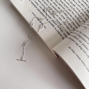 Detail of 925 sterling silver anchor link necklace with toggle clasp on a book