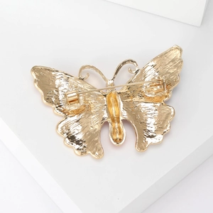 Golden butterfly brooch with rhinestone detail showing professional back pin structure
