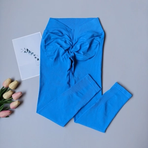 Détail du legging de yoga bleu taille haute avec ceinture en V et effet fessier froncé