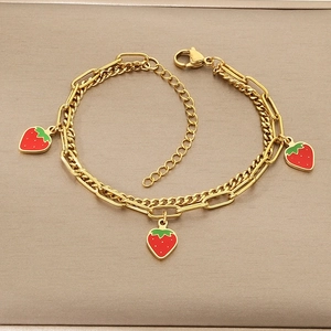 Detail of gold double-layer bracelet with strawberry charms and lobster clasp closure