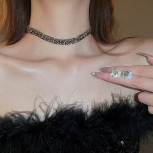 Close-up of sparkling cubic zirconia necklace and stud earring set on model neck