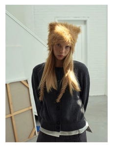 Close-up of fluffy brown cat ear hat and grey knit cardigan on a model in studio