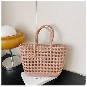 Detail of pink hollow-out woven jelly tote bag showing texture in a lifestyle setting