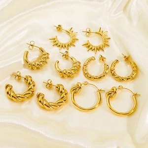 Five pairs of 14K gold-plated C-shaped hoop earrings with textured spiral and sunburst patterns