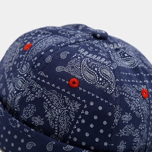 Detailed macro of navy blue paisley fabric with high-contrast red embroidered ventilation eyelet