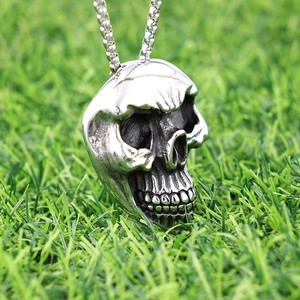Vintage pirate skull pendant in polished stainless steel on a silver box chain outdoors