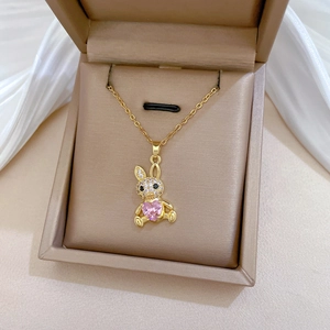 Gold rabbit necklace with pink heart gem and pavé crystals in a beige velvet gift box