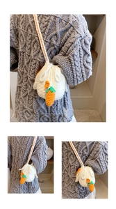 Detail of hand-woven rabbit ear bucket bag with carrot accents and drawstring closure