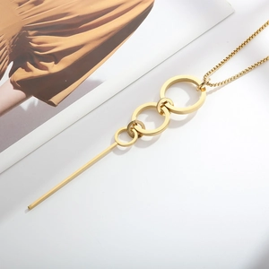 Detail view of gold titanium sweater necklace with interlocking rings and long bar pendant