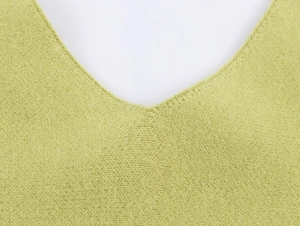 Detail shot of the V-neckline and fine knit texture on this light green knit sweater